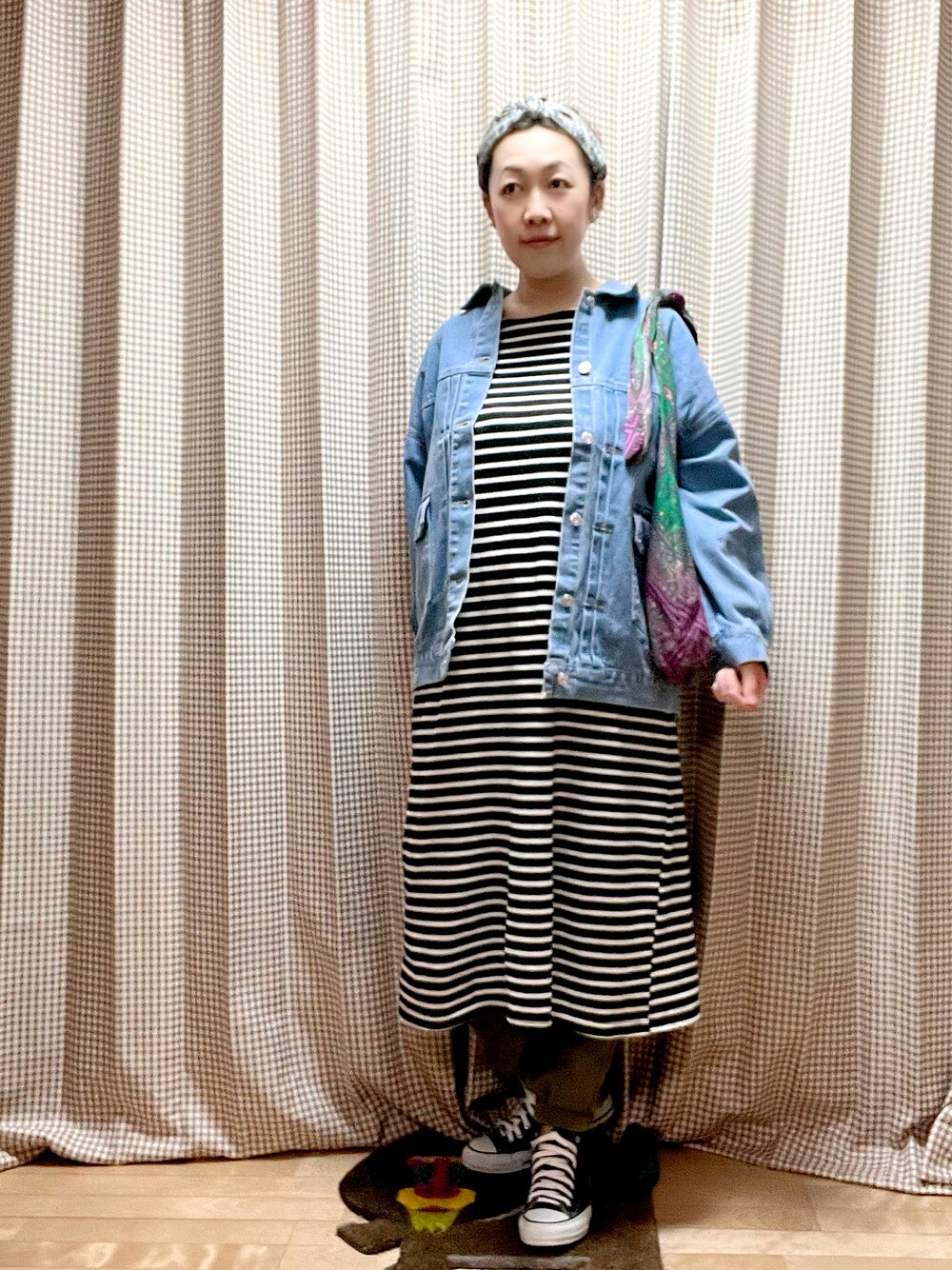 ブラック系のワンピース、ブルー系のデニムジャケット、ピンク系のショルダーバッグを着用したレディースの春コーディネートの1枚目の写真