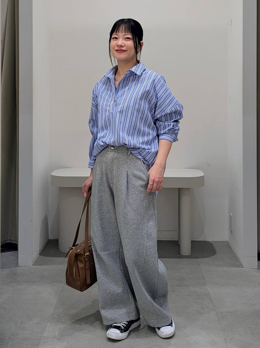 グレー系のスウェットパンツ、イエロー系のボストンバッグ、ブルー系のシャツ/ブラウスを着用したレディースの冬コーディネートの1枚目の写真