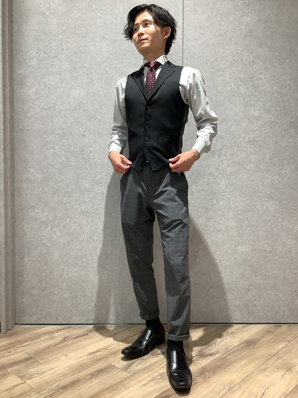 グレー系のビジネスシャツ、レッド系のネクタイを着用したメンズの冬コーディネートの1枚目の写真