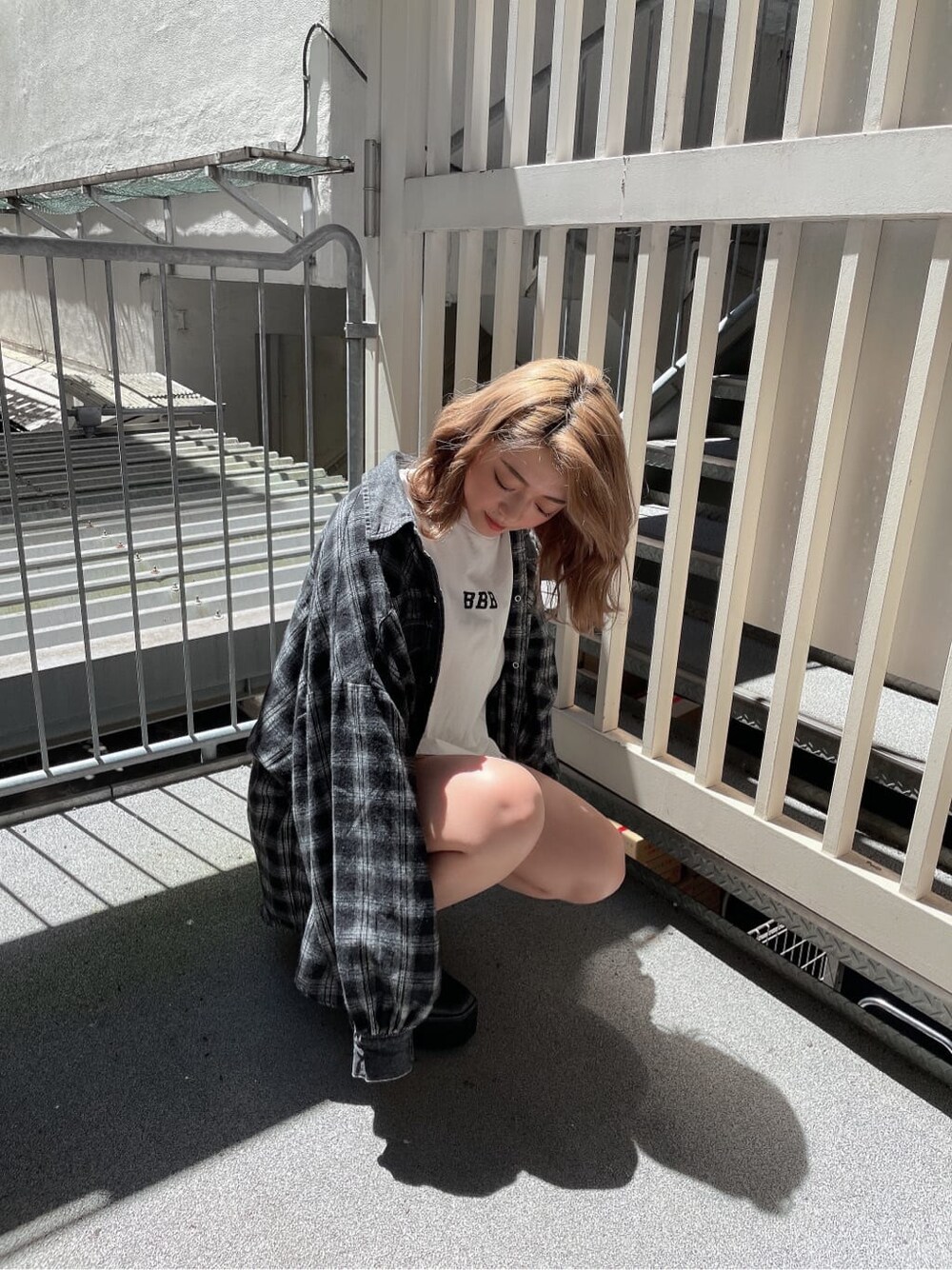 ブラック系のシャツ/ブラウス、ブラック系のブーツ、ホワイト系のTシャツ/カットソーを着用したレディースの夏コーディネートの1枚目の写真