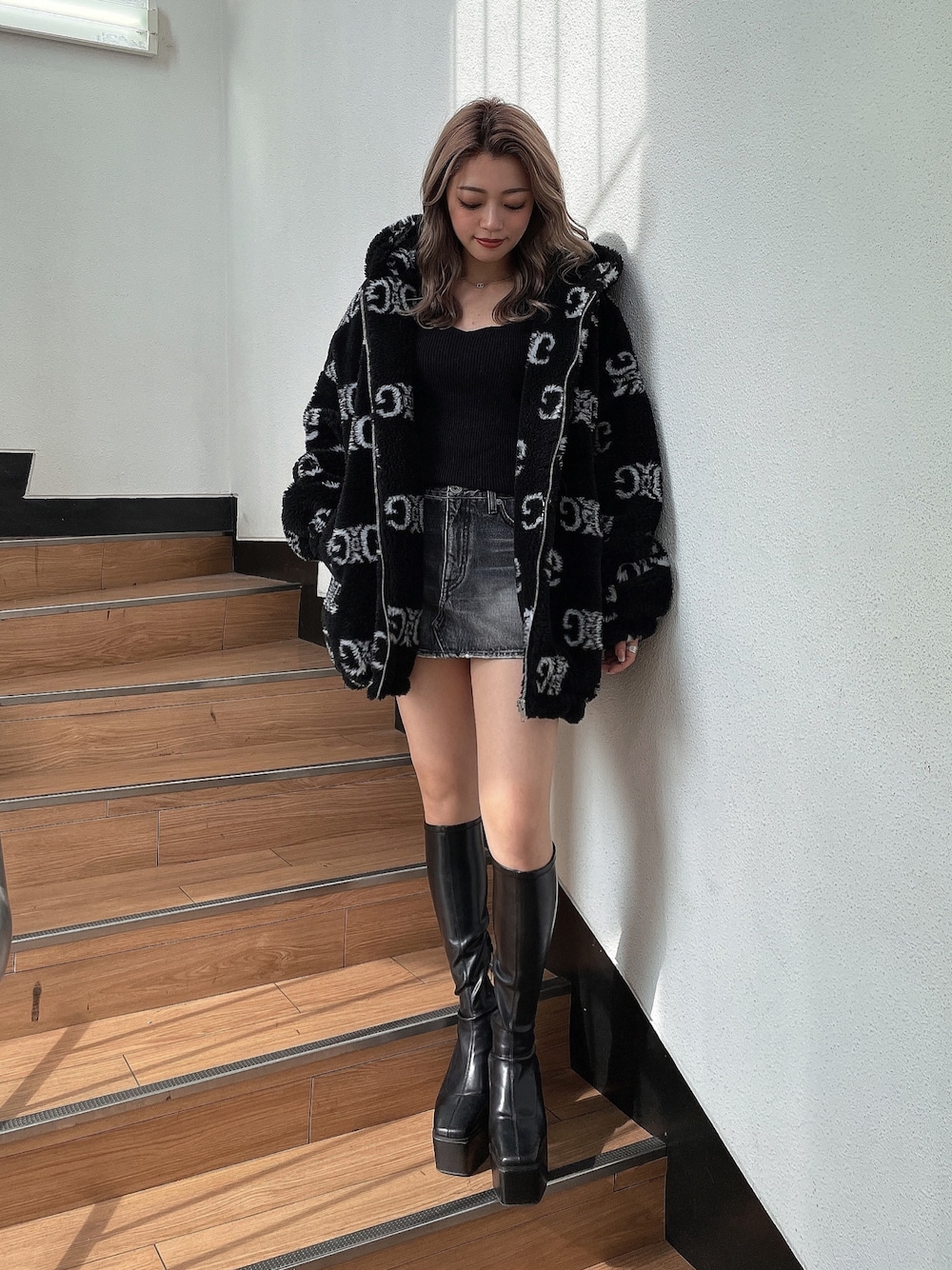 ブラック系のニット/セーター、ブラック系のブルゾン、ブラック系のブーツを着用したレディースの秋コーディネートの1枚目の写真