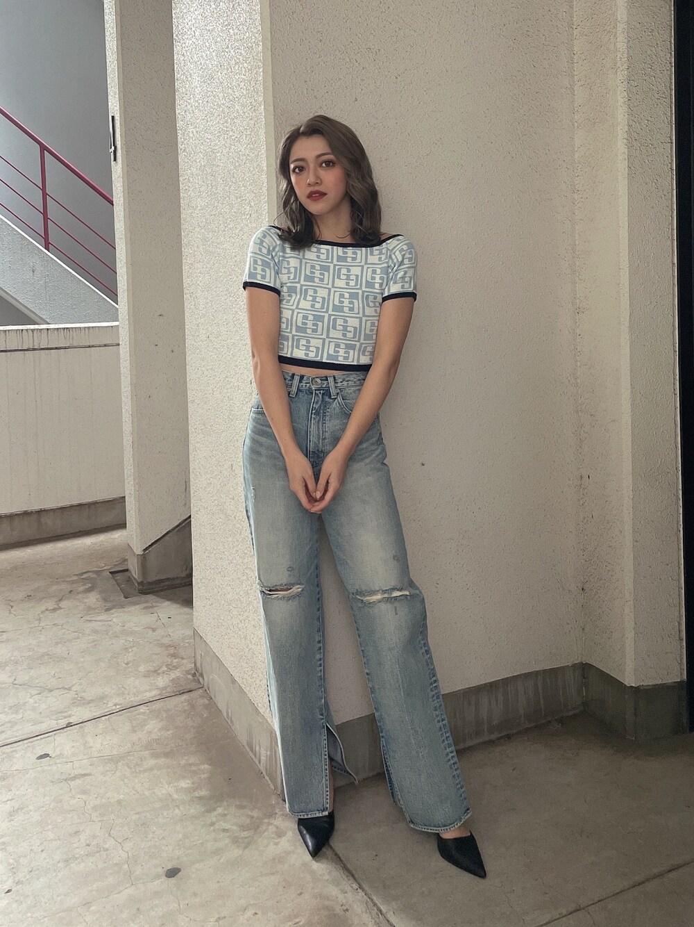 ブルー系のニット/セーター、ブルー系のデニムパンツ、ブラック系のパンプスを着用したレディースの冬コーディネートの1枚目の写真