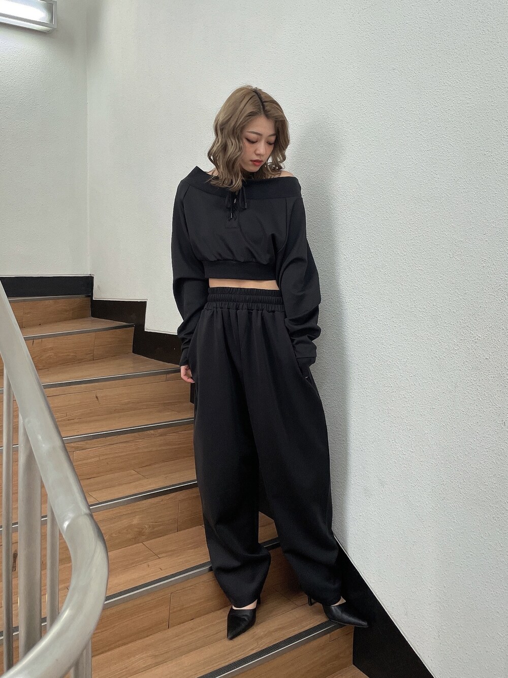 ブラック系のTシャツ/カットソー、ブラック系のスウェットパンツ、ブラック系のパンプスを着用したレディースの冬コーディネートの1枚目の写真