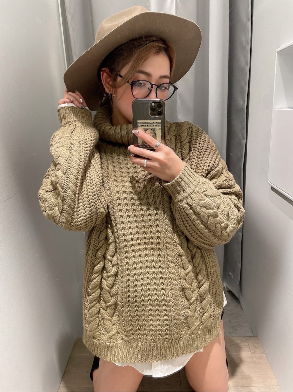 ブラック系のブーツ、ブラック系のデニムパンツ、ベージュ系のニット/セーターを着用したレディースの秋コーディネートの1枚目の写真