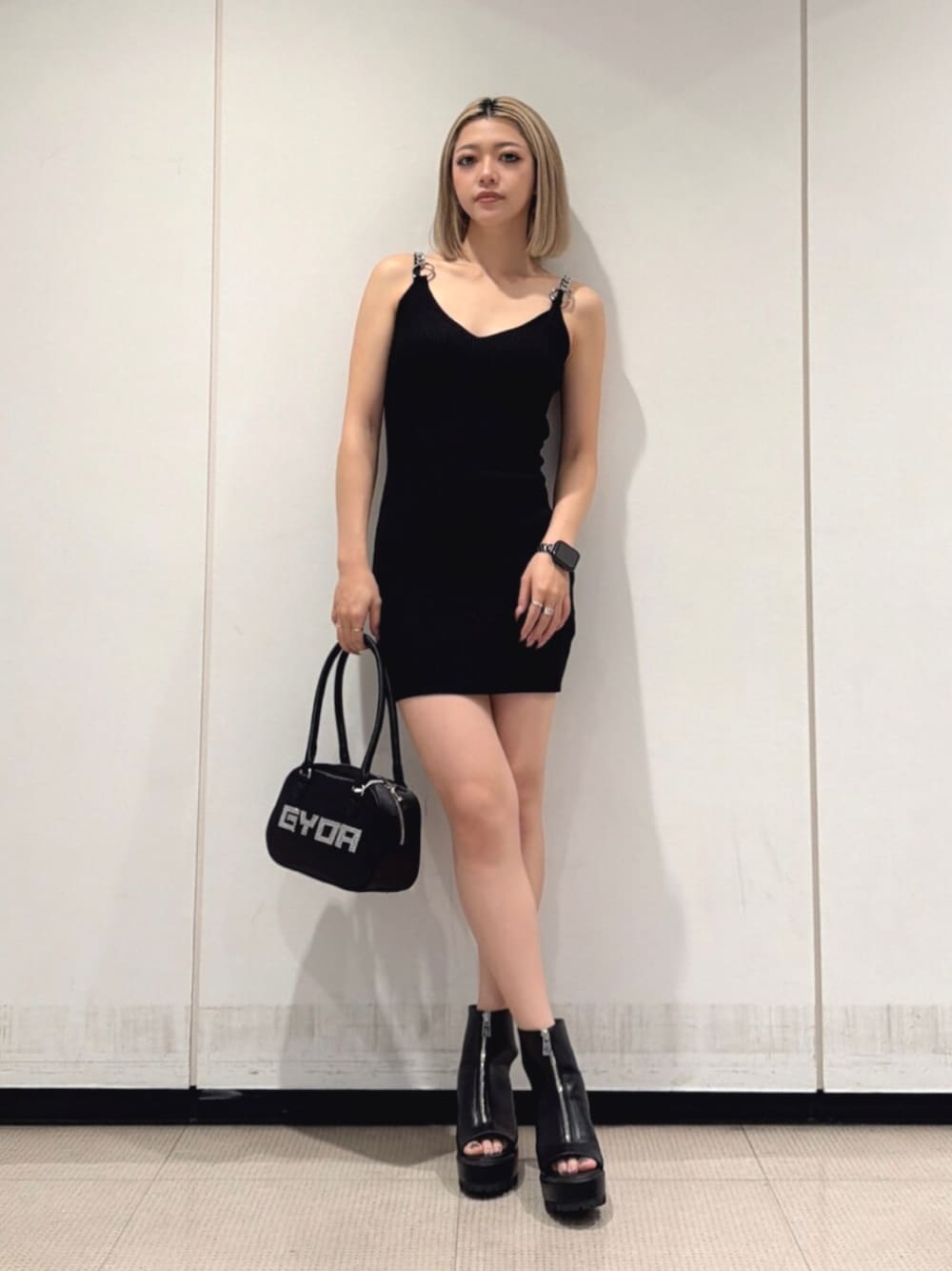 ブラック系のブーツ、ブラック系のボストンバッグ、ブラック系のワンピースを着用したレディースの夏コーディネートの1枚目の写真