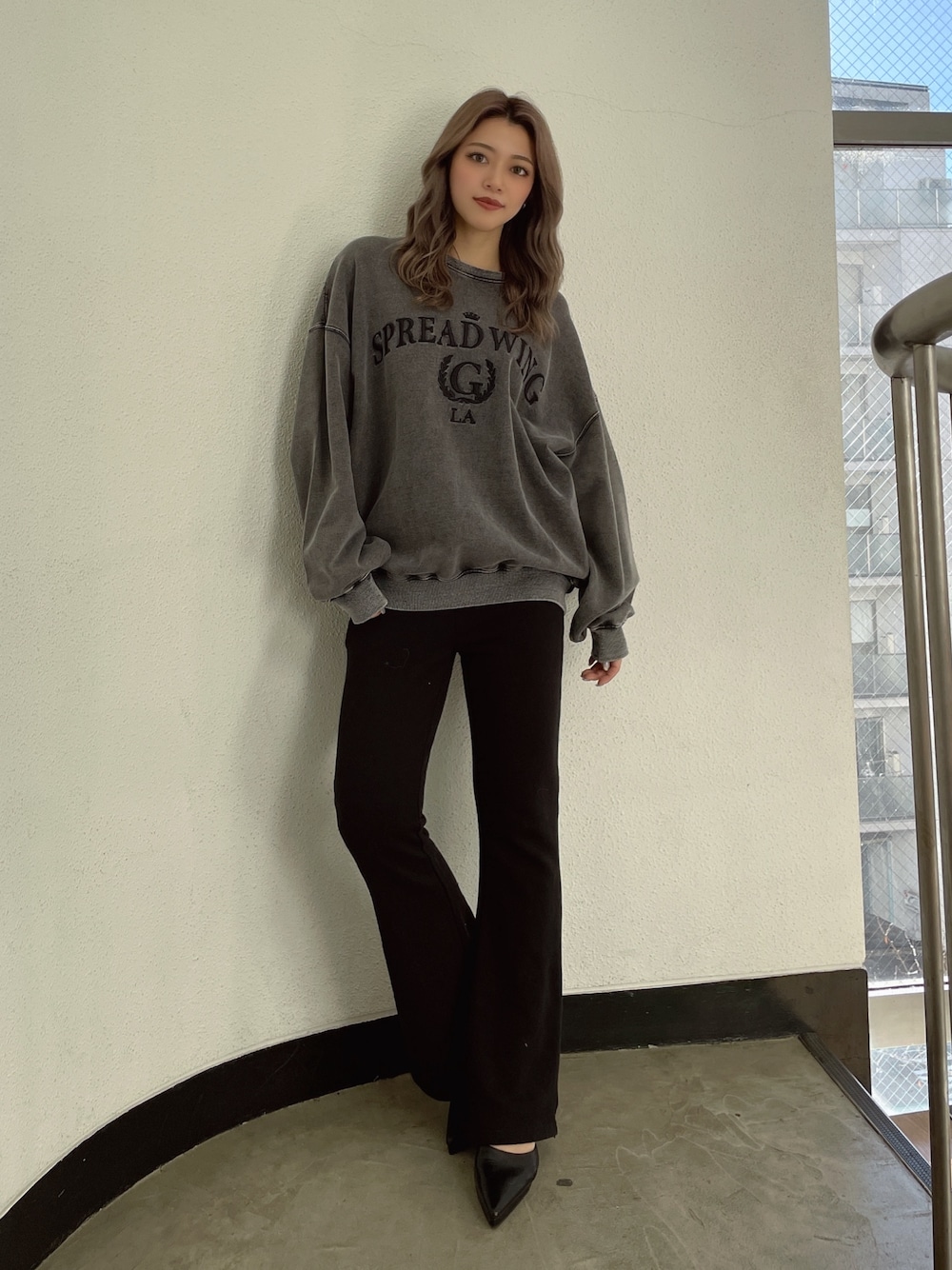 グレー系のスウェット、ブラック系のスウェットパンツ、ブラック系のパンプスを着用したレディースの冬コーディネートの1枚目の写真