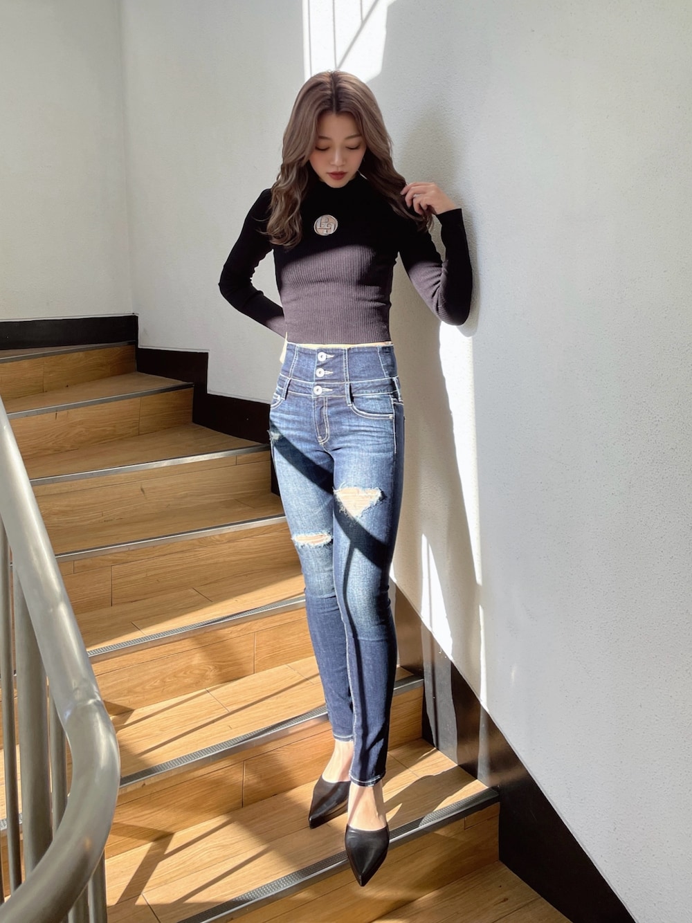 ブラック系のニット/セーター、ブラック系のパンプス、ブルー系のデニムパンツを着用したレディースの冬コーディネートの1枚目の写真