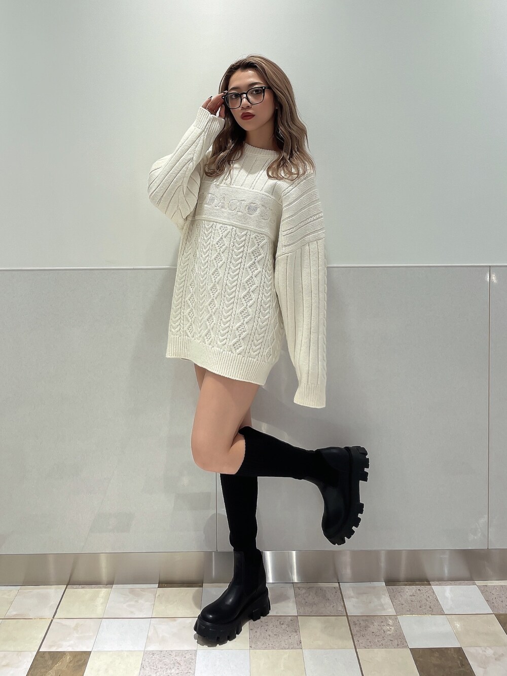 ホワイト系のニット/セーター、ブラック系のブーツを着用したレディースの秋コーディネートの1枚目の写真