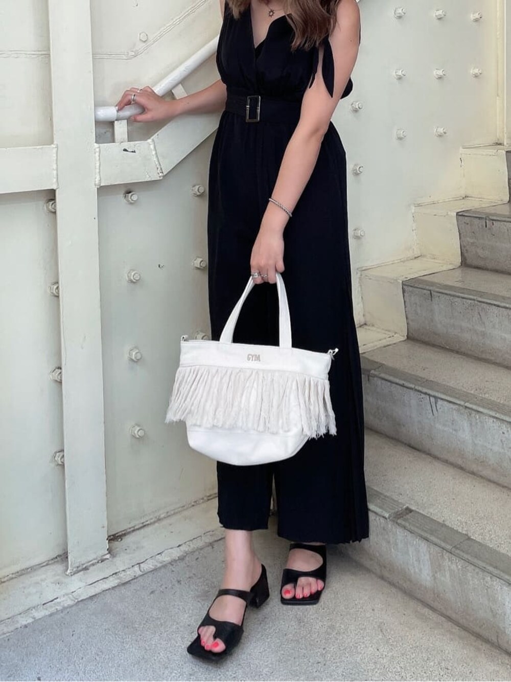 ブラック系のつなぎ/オールインワン、ブラック系のサンダル、ホワイト系のハンドバッグを着用したレディースの夏コーディネートの1枚目の写真