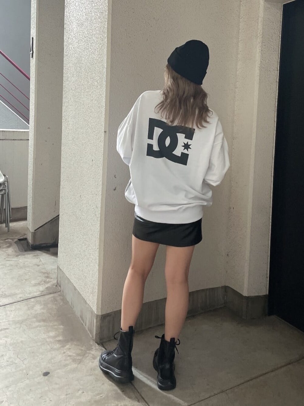ブラック系のブーツ、ブラック系のスカート、ホワイト系のTシャツ/カットソーを着用したレディースの秋コーディネートの1枚目の写真