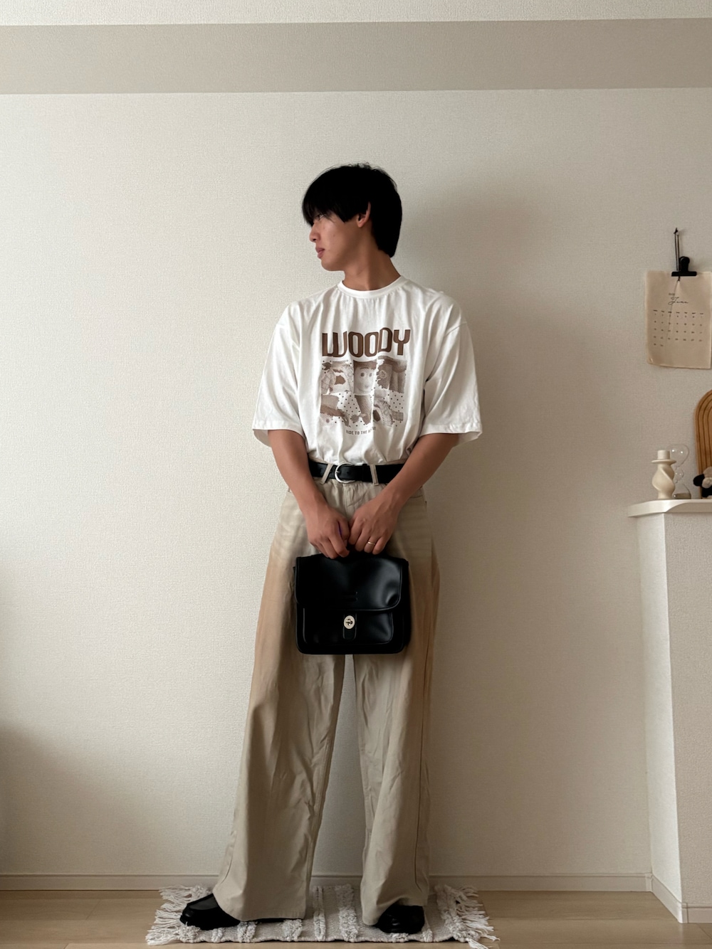 ホワイト系のTシャツ/カットソー、グリーン系のデニムパンツ、ブラック系のショルダーバッグを着用したメンズの夏コーディネートの1枚目の写真