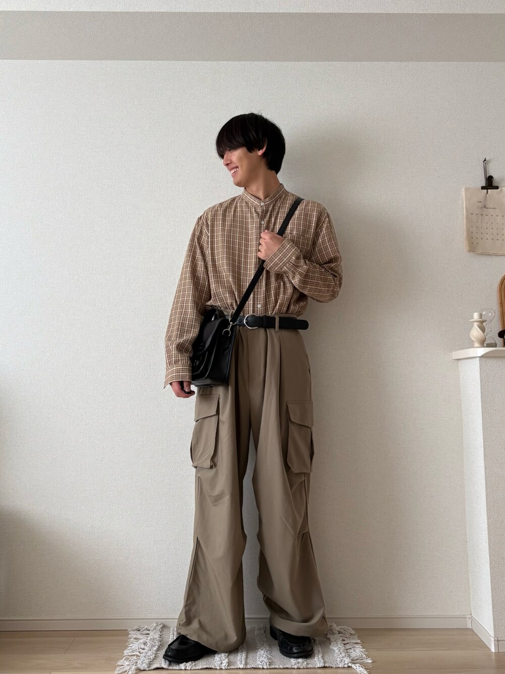 ベージュ系のその他パンツ、ブラック系のショルダーバッグ、ベージュ系のシャツ/ブラウスを着用したメンズの春コーディネートの1枚目の写真