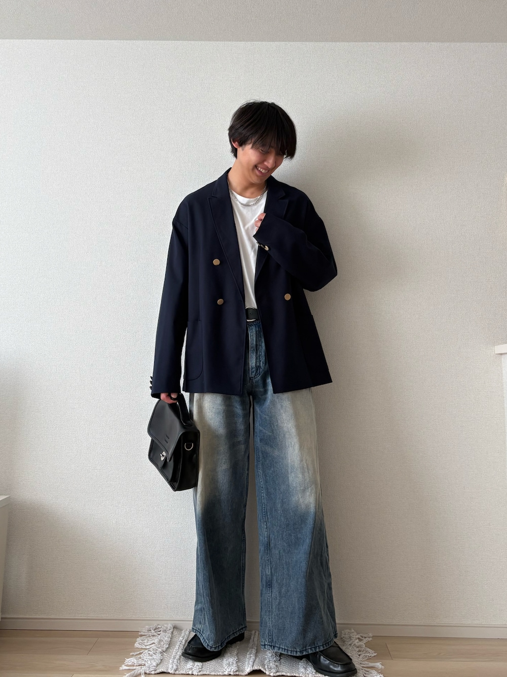 ブラック系のテーラードジャケット、ブルー系のデニムパンツ、ブラック系のショルダーバッグを着用したメンズの春コーディネートの1枚目の写真