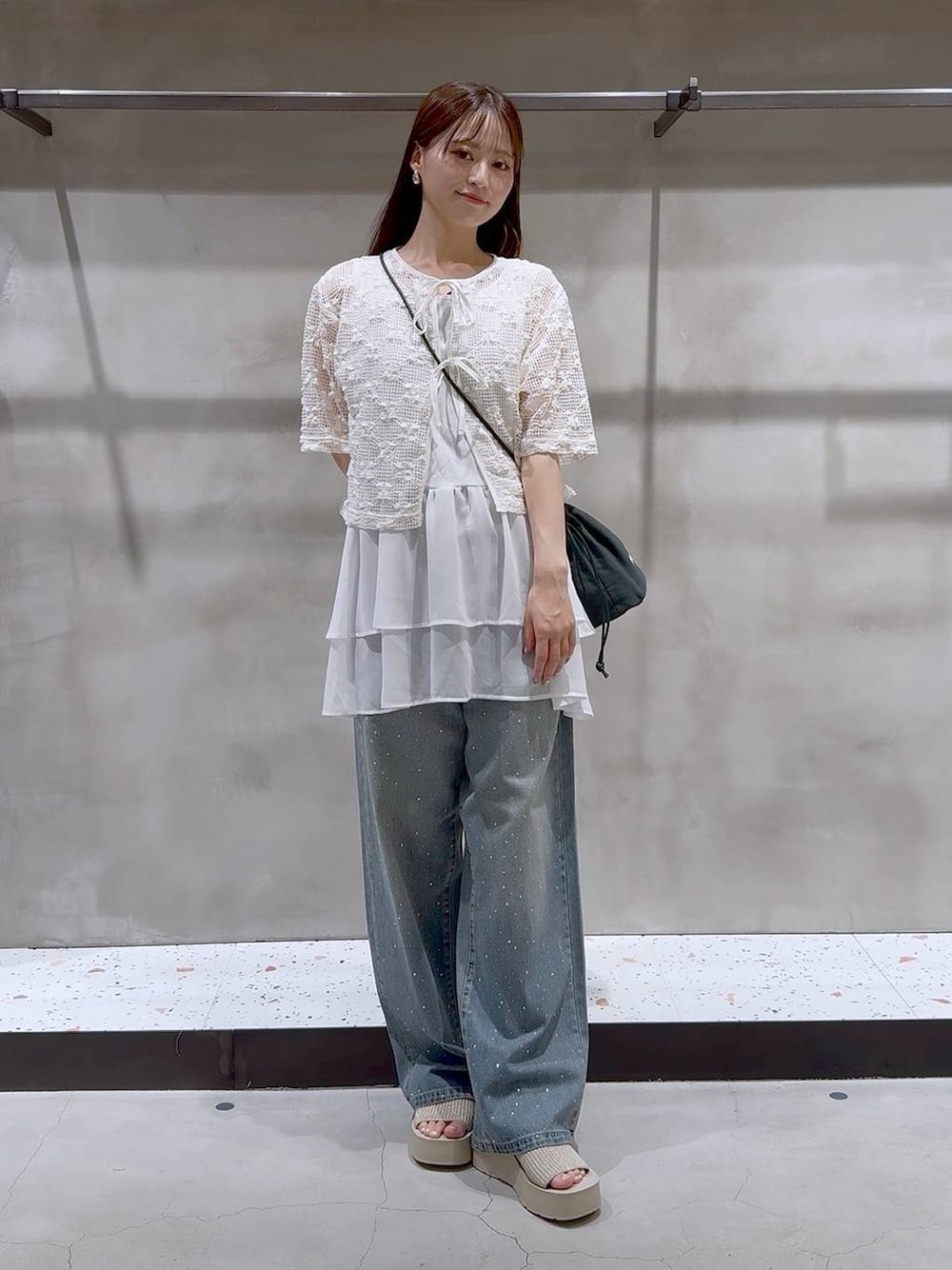 ブルー系のデニムパンツ、ホワイト系のサンダル、ホワイト系のタンクトップを着用したレディースの夏コーディネートの1枚目の写真