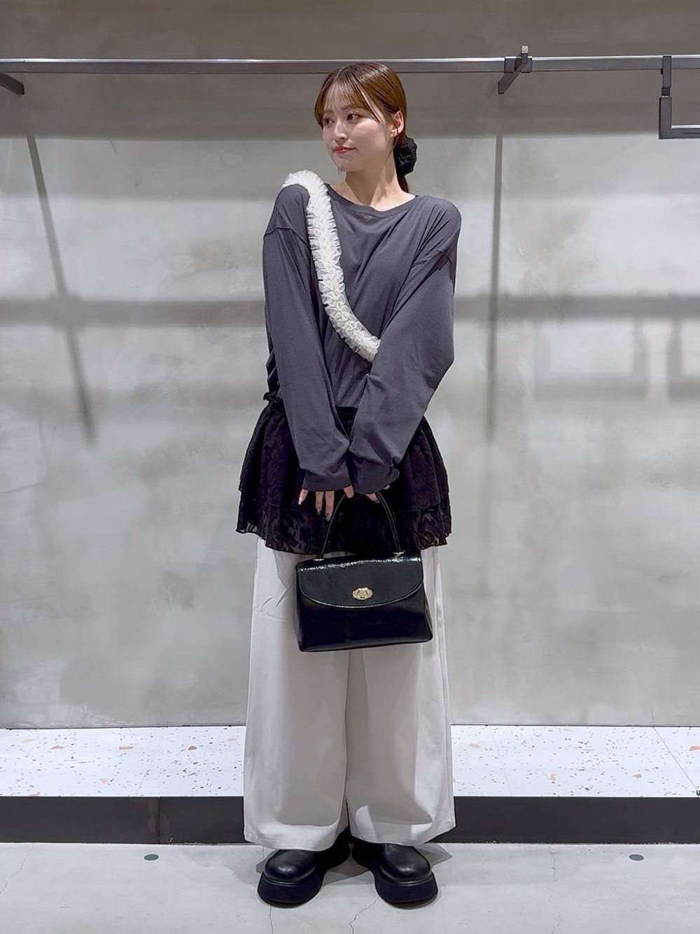 ブラック系のキャミソール、ブラック系のボストンバッグ、ブラック系のサンダルを着用したレディースの秋コーディネートの1枚目の写真