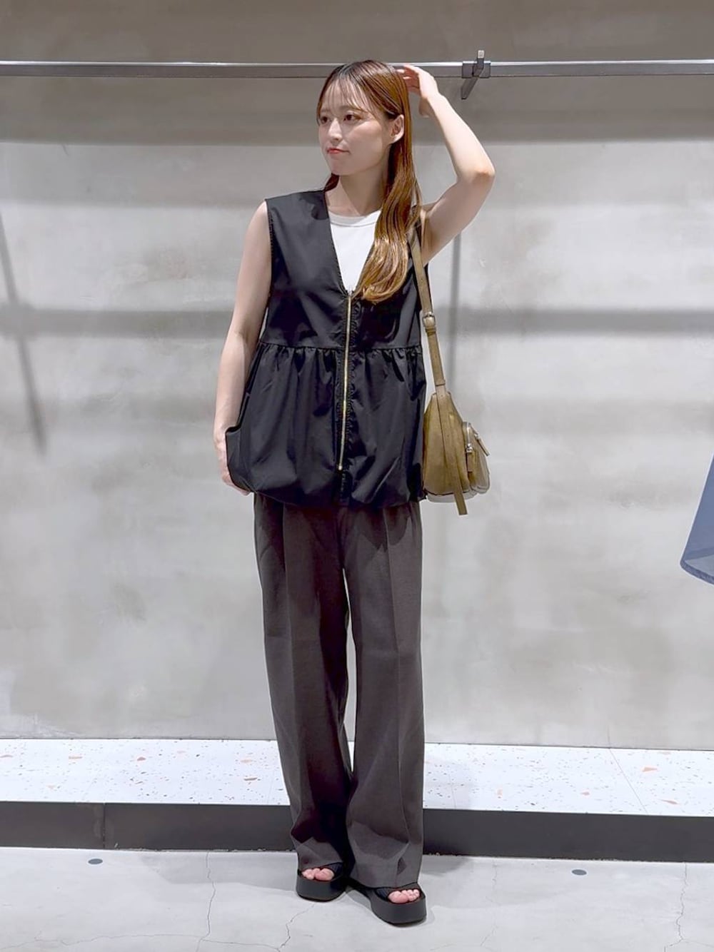 ブラック系のサンダル、ホワイト系のキャミソール、グレー系のスラックスを着用したレディースの夏コーディネートの1枚目の写真