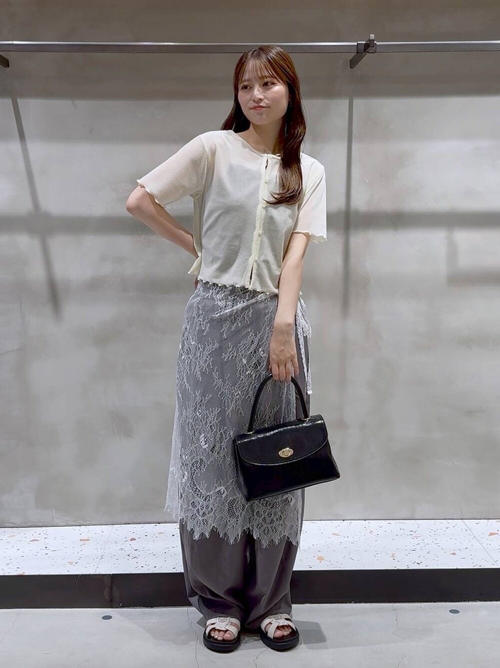ホワイト系のサンダル、グレー系のその他パンツ、ブラック系のボストンバッグを着用したレディースの夏コーディネートの1枚目の写真