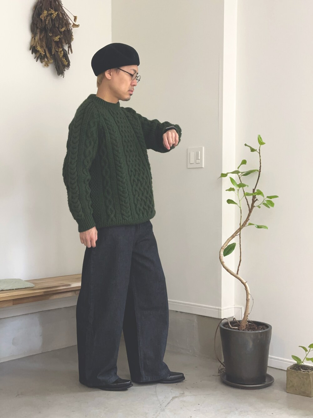グリーン系のニット/セーター、ブラック系のデニムパンツ、ブラック系のブーツを着用したメンズの秋コーディネートの1枚目の写真