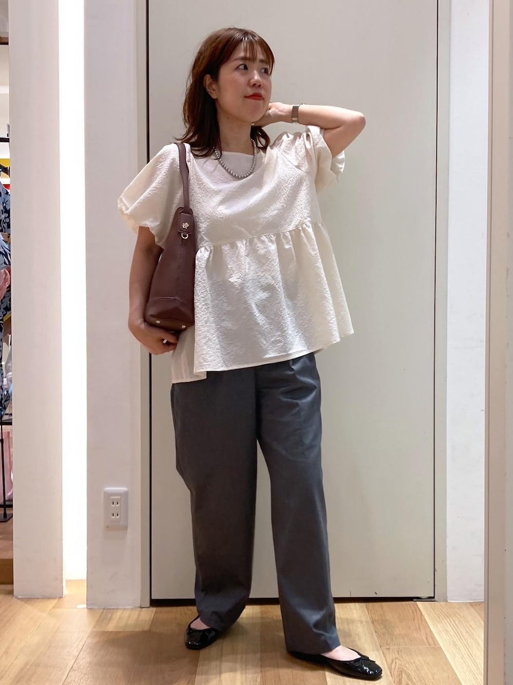 ブラック系のバレエシューズ、グレー系のチノパンツ、ホワイト系のシャツ/ブラウスを着用したレディースの夏コーディネートの1枚目の写真