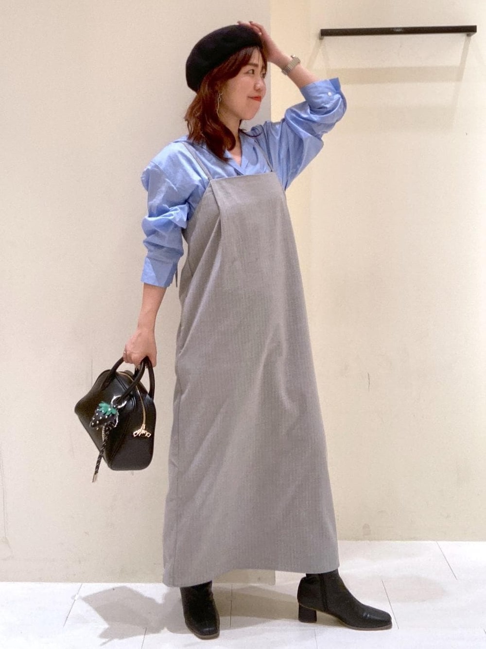 グレー系のワンピース、ブルー系のシャツ/ブラウス、ブラック系のボストンバッグを着用したレディースの秋コーディネートの1枚目の写真