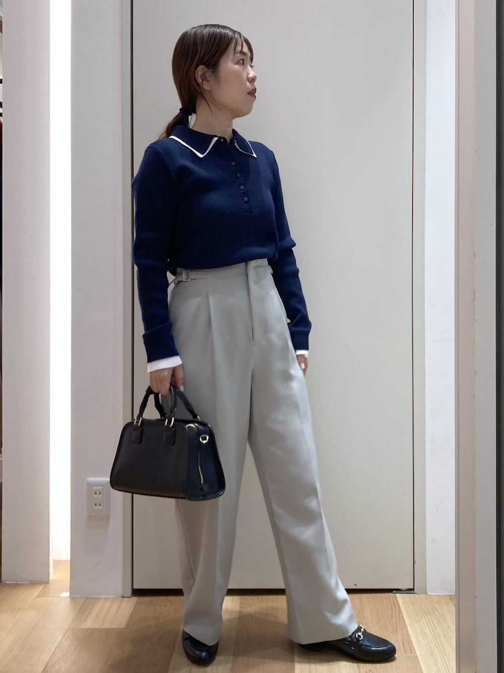 ブラック系のローファー、ブラック系のボストンバッグ、グリーン系のその他パンツを着用したレディースの冬コーディネートの1枚目の写真