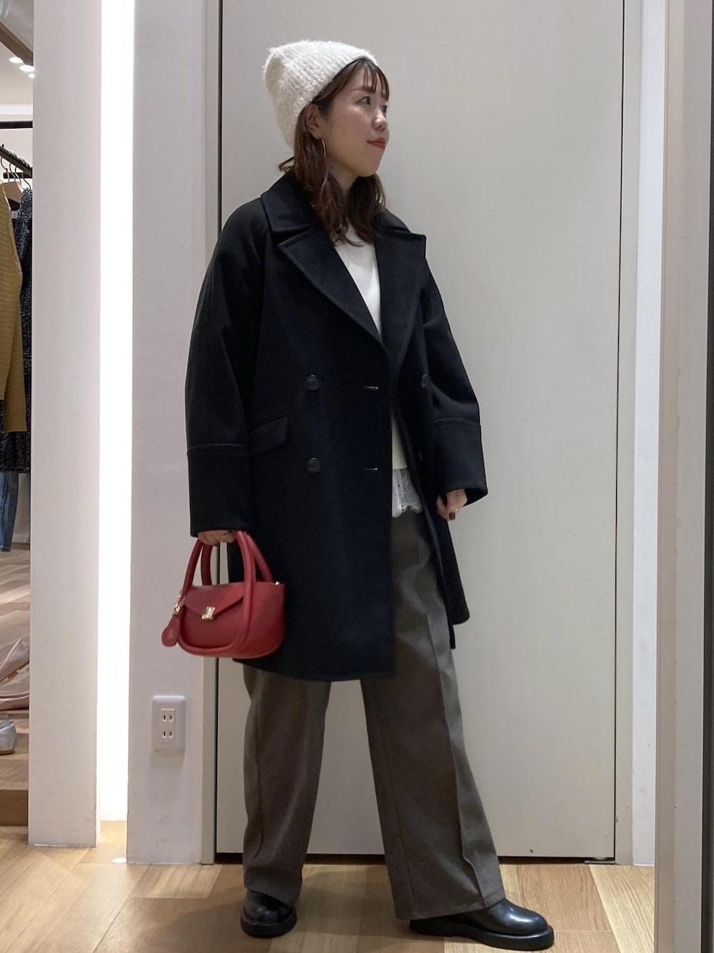 ホワイト系のニット/セーター、ブラウン系のその他パンツ、ブラック系のピーコートを着用したレディースの冬コーディネートの1枚目の写真