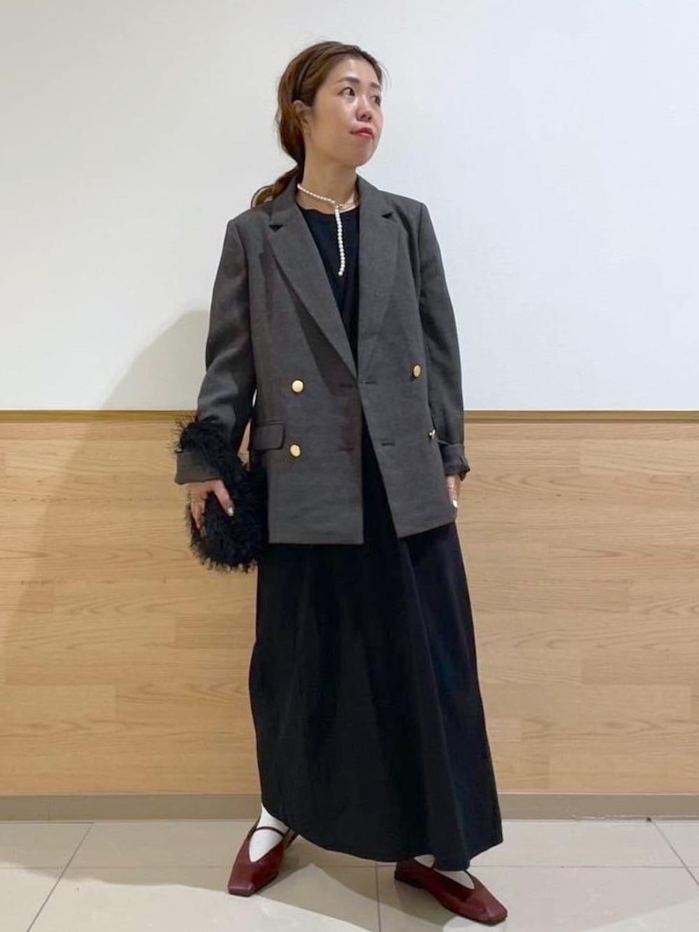 ブラウン系のテーラードジャケット、ブラック系のハンドバッグ、ブラック系のワンピースを着用したレディースの秋コーディネートの1枚目の写真