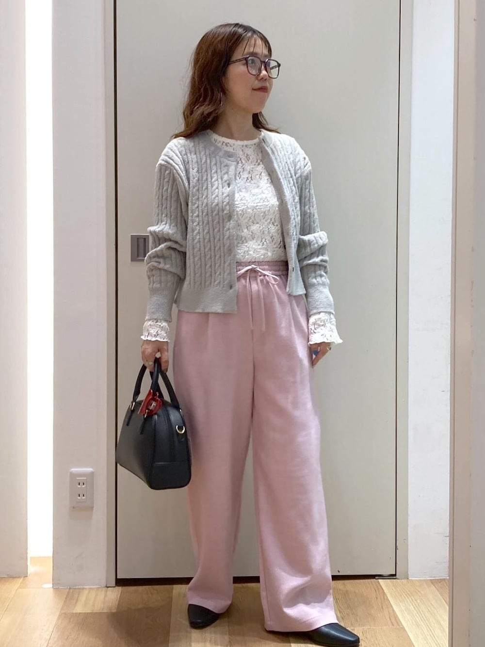 ピンク系のその他パンツ、グレー系のカーディガン/ボレロ、ブラック系のブーツを着用したレディースの秋コーディネートの1枚目の写真