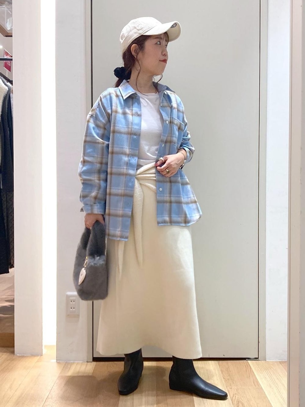 ホワイト系のスカート、ブルー系のシャツ/ブラウス、ブラック系のブーツを着用したレディースの秋コーディネートの1枚目の写真