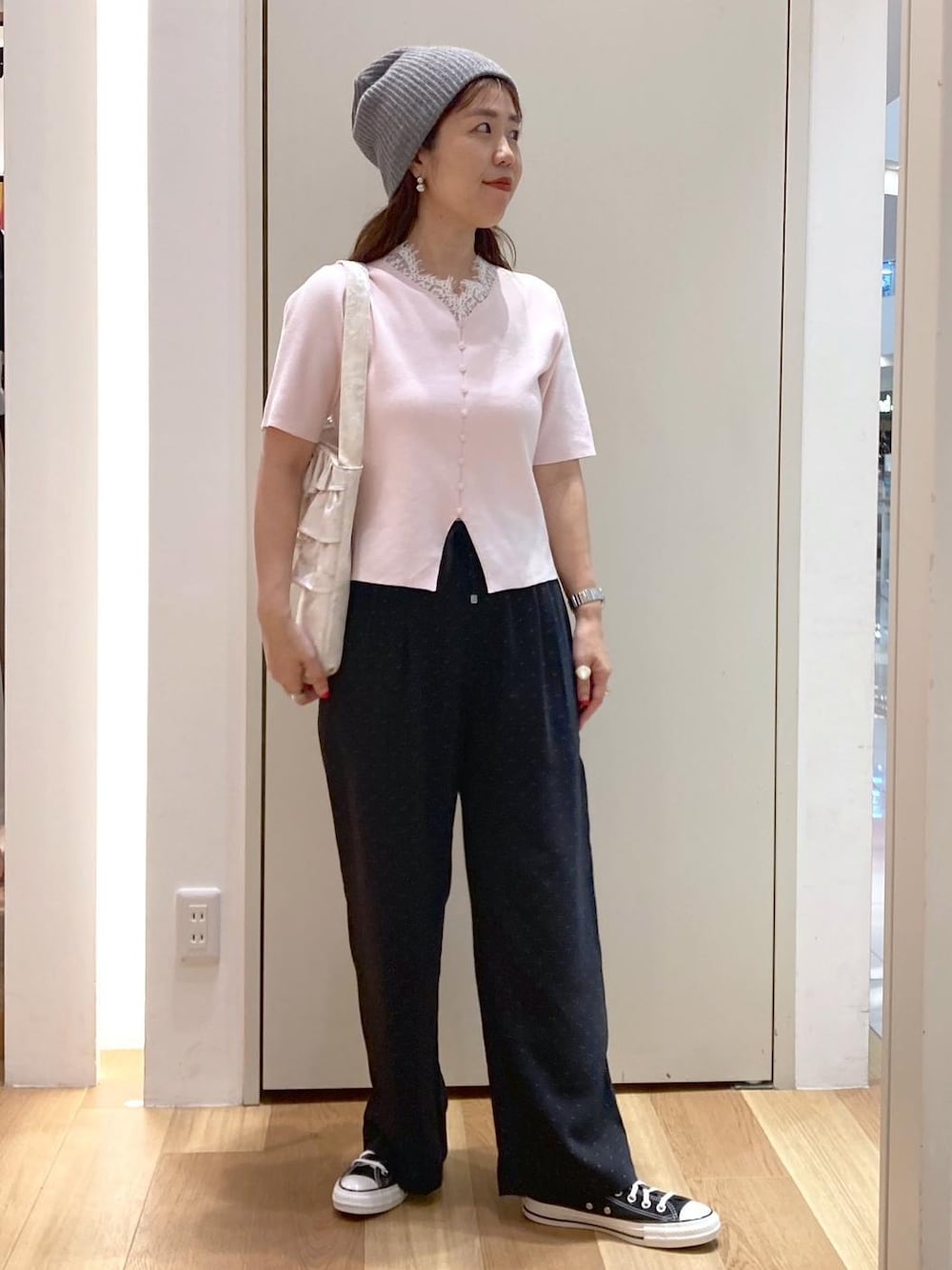 ピンク系のニット/セーター、ブラック系のその他パンツ、ホワイト系のトートバッグを着用したレディースの夏コーディネートの1枚目の写真