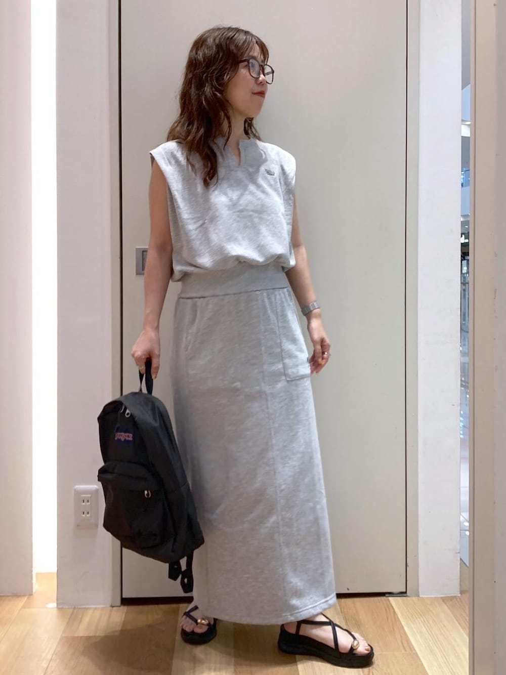 ブラック系のサンダル、グレー系のスカート、グレー系のTシャツ/カットソーを着用したレディースの夏コーディネートの1枚目の写真