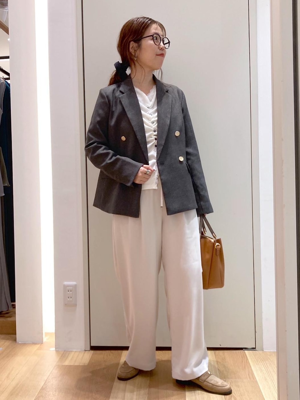 ブラウン系のトートバッグ、ホワイト系のその他パンツ、ブラウン系のテーラードジャケットを着用したレディースの秋コーディネートの1枚目の写真