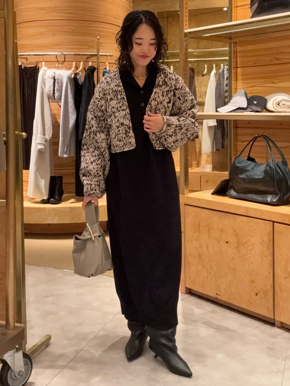 ブラック系のカーディガン/ボレロ、ブラック系のワンピース、ブラック系のブーツを着用したレディースの秋コーディネートの1枚目の写真