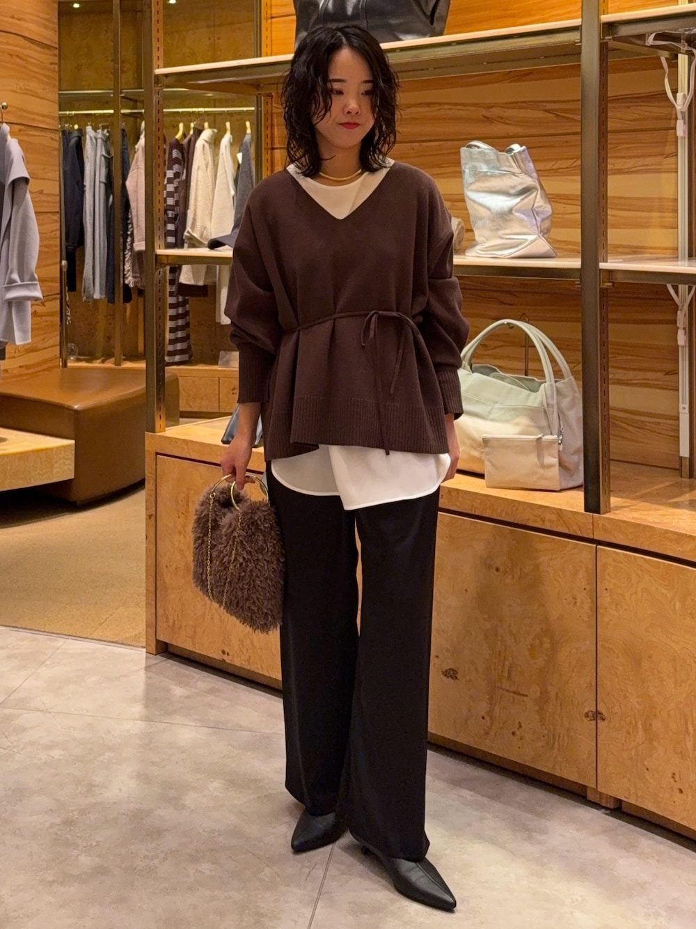 ブラウン系のニット/セーター、ホワイト系のシャツ/ブラウス、ブラック系のその他パンツを着用したレディースの秋コーディネートの1枚目の写真