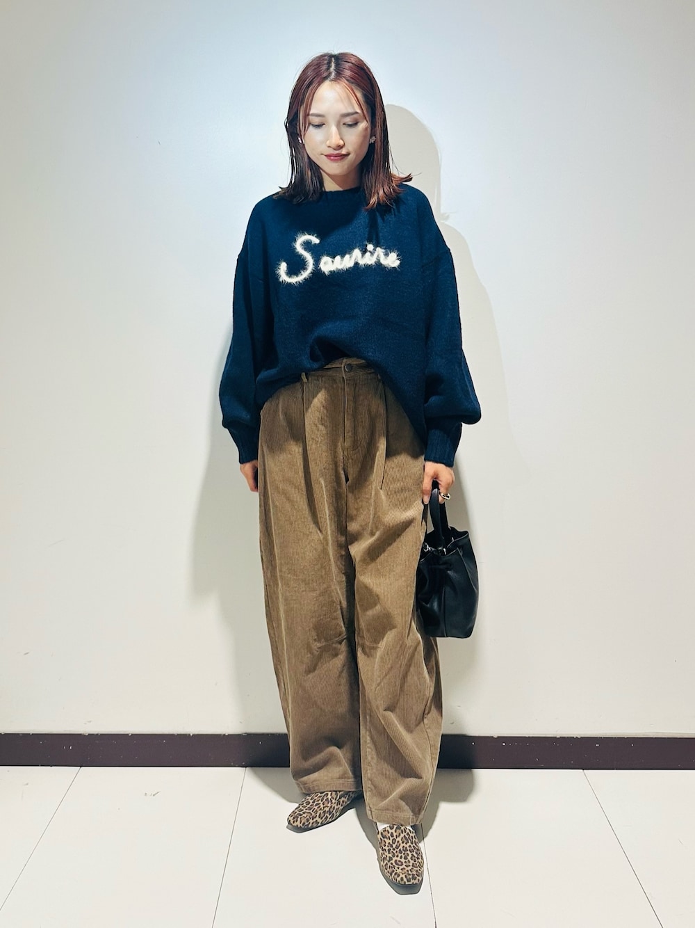 ブルー系のニット/セーター、ベージュ系のその他パンツ、ブラック系のショルダーバッグを着用したレディースの秋コーディネートの1枚目の写真