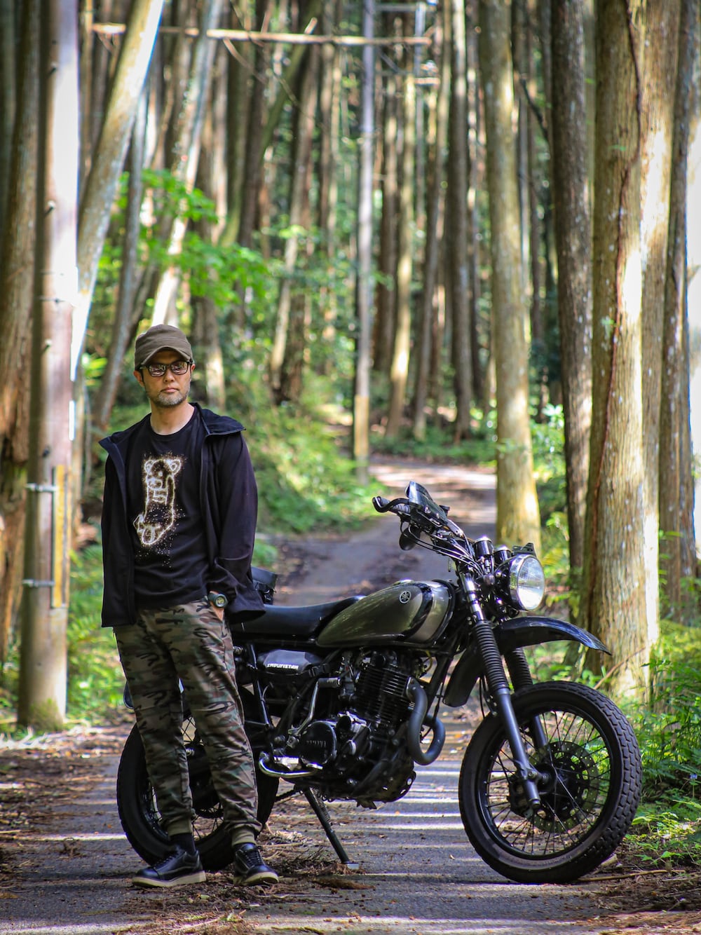 ブラック系のTシャツ/カットソー、ブラック系のパーカー、グリーン系のスウェットパンツを着用したメンズの春コーディネートの1枚目の写真