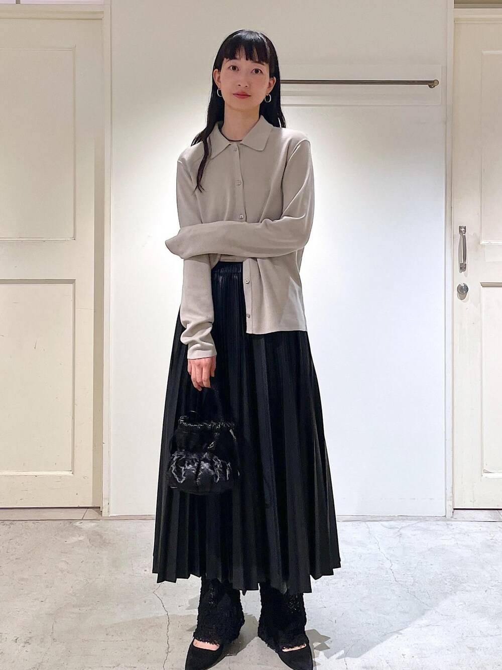 グレー系のカーディガン/ボレロ、ブラック系のスカート、ブラック系のショルダーバッグを着用したレディースの秋コーディネートの1枚目の写真