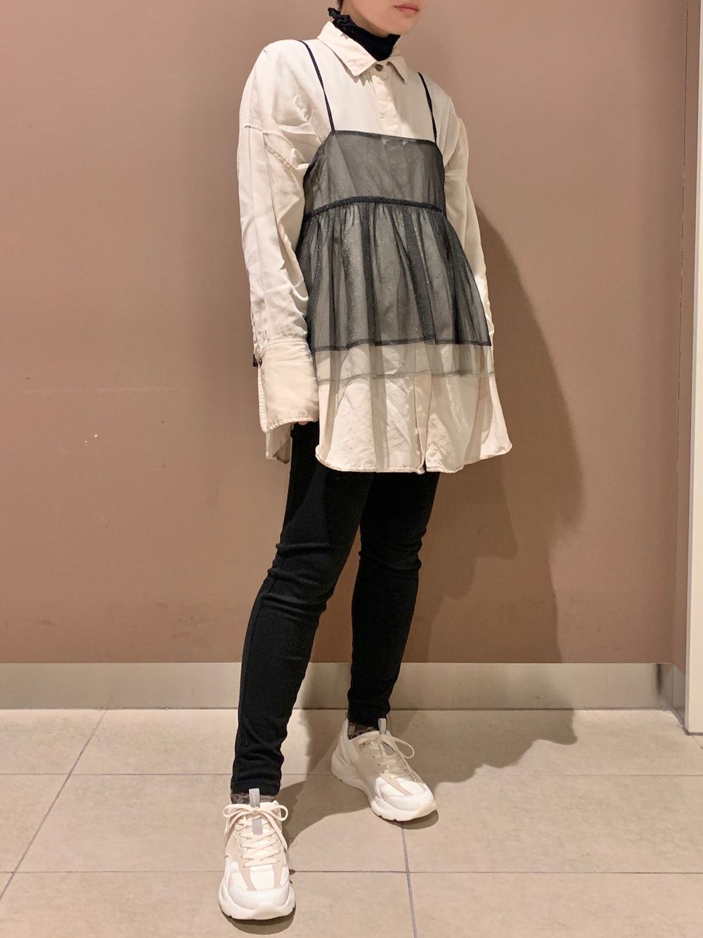 ホワイト系のスニーカーを着用したレディースの春コーディネートの1枚目の写真