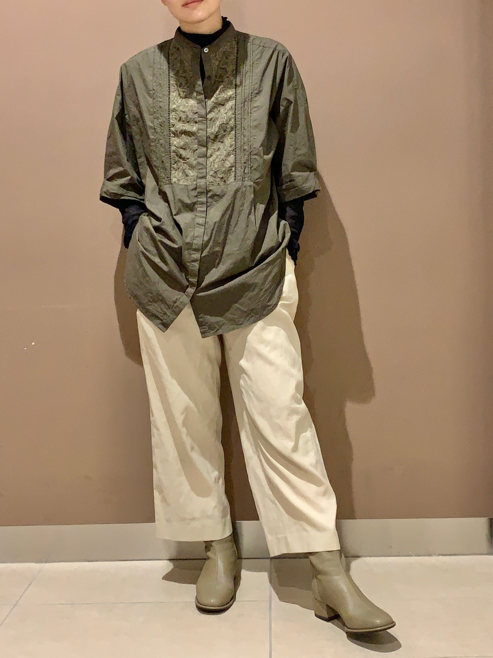 グレー系のブーツを着用したレディースの秋コーディネートの1枚目の写真