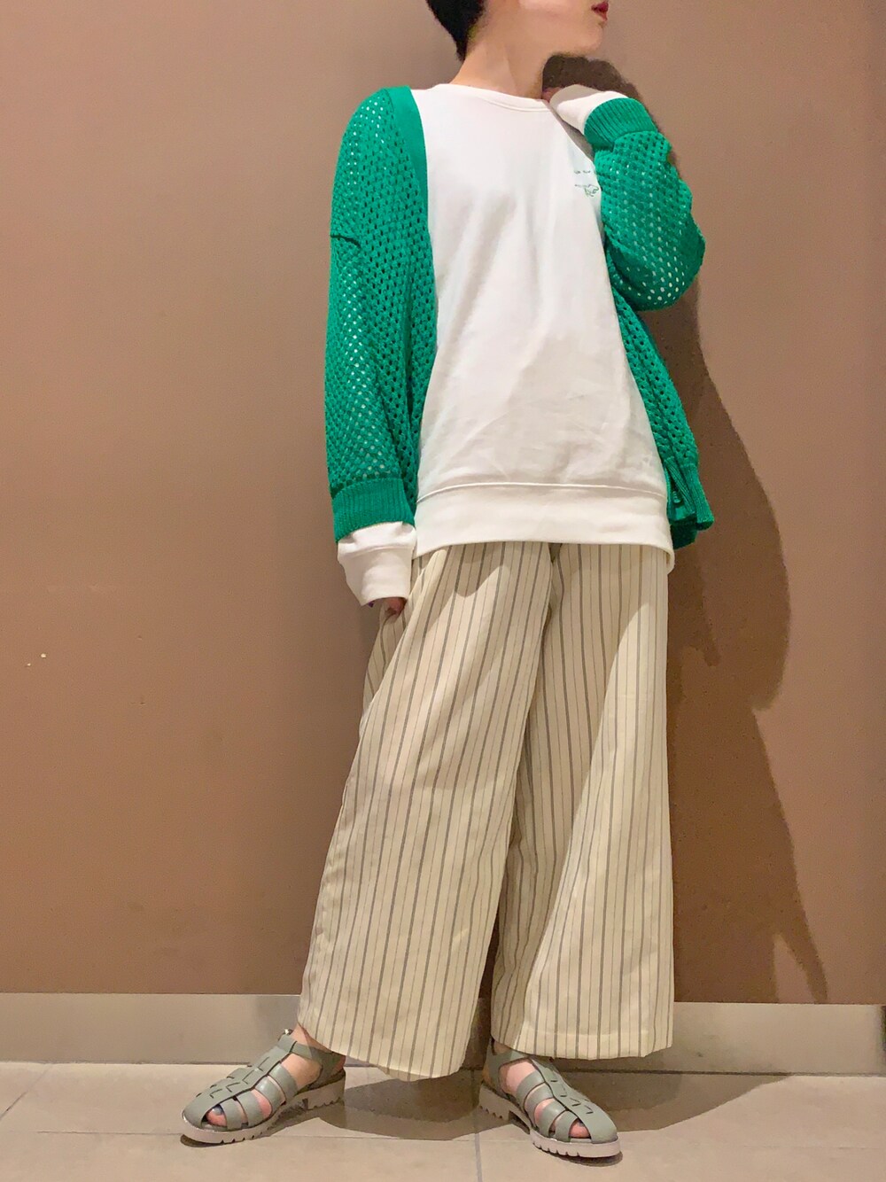 グリーン系のサンダルを着用したレディースの春コーディネートの1枚目の写真