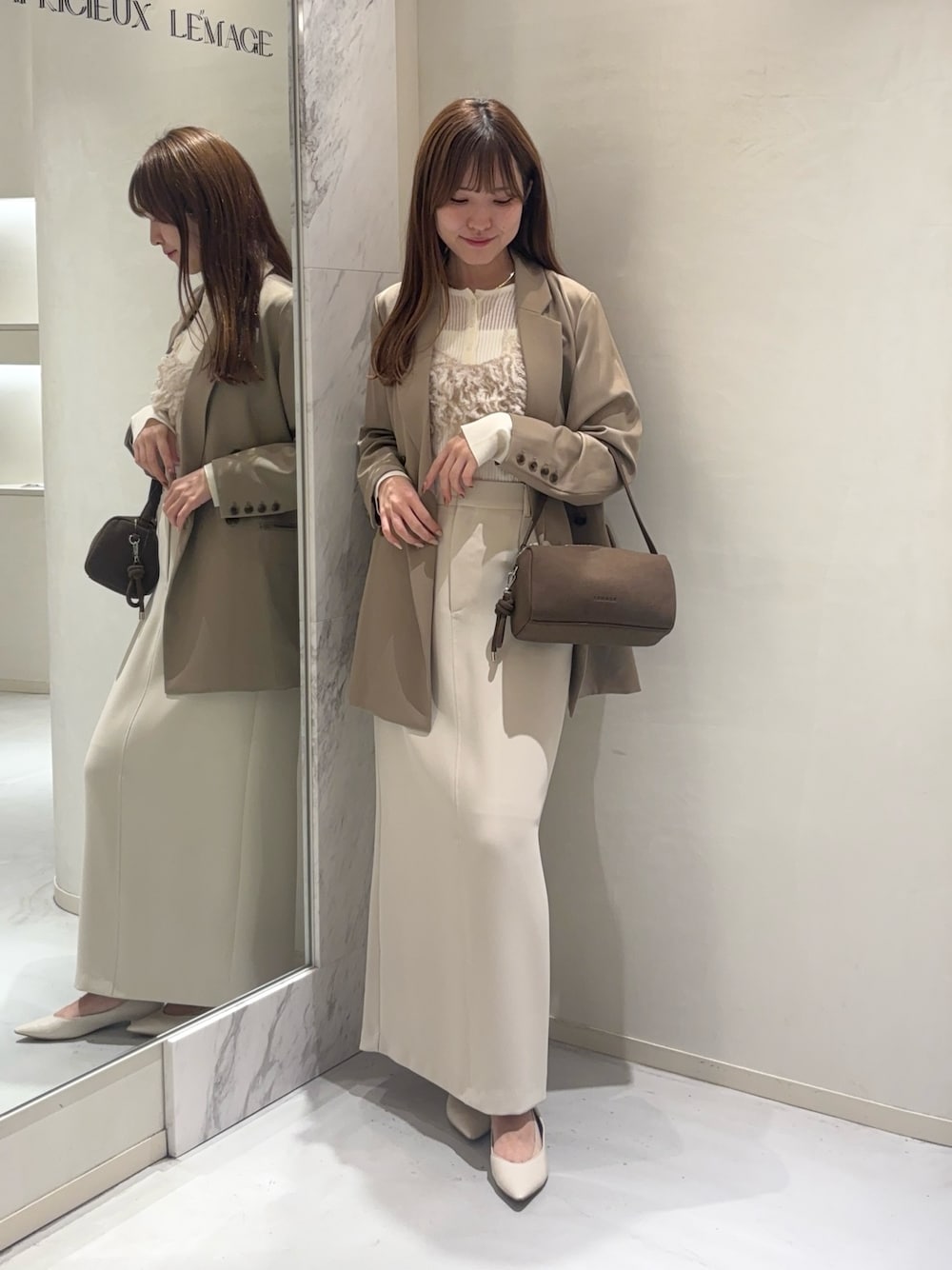 ベージュ系のテーラードジャケット、ベージュ系のTシャツ/カットソー、ホワイト系のニット/セーターを着用したレディースの秋コーディネートの1枚目の写真