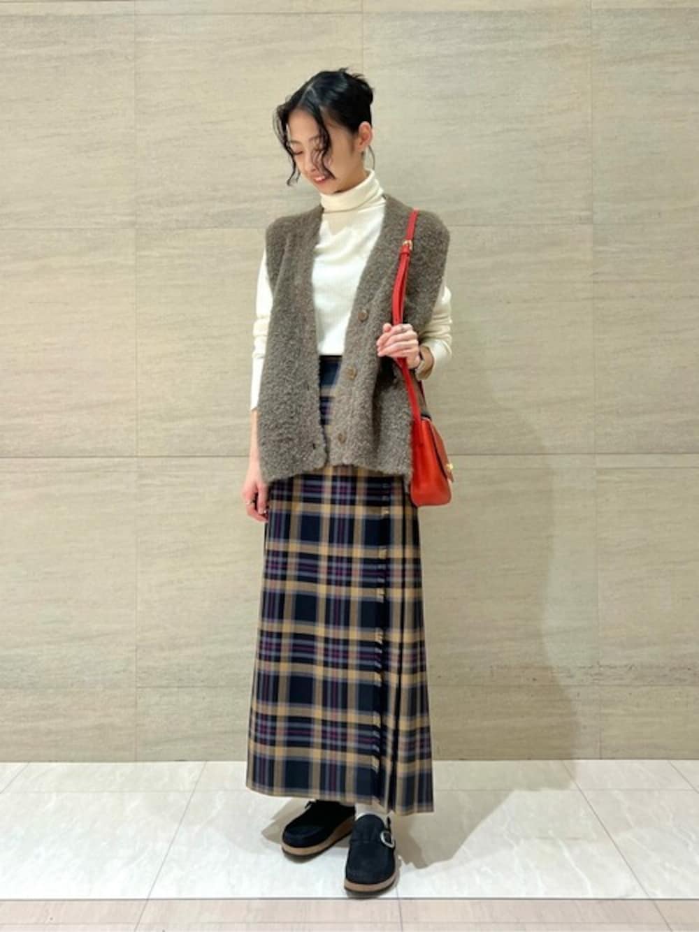 ホワイト系のTシャツ/カットソー、グレー系のベスト、その他のスカートを着用したレディースの秋コーディネートの1枚目の写真