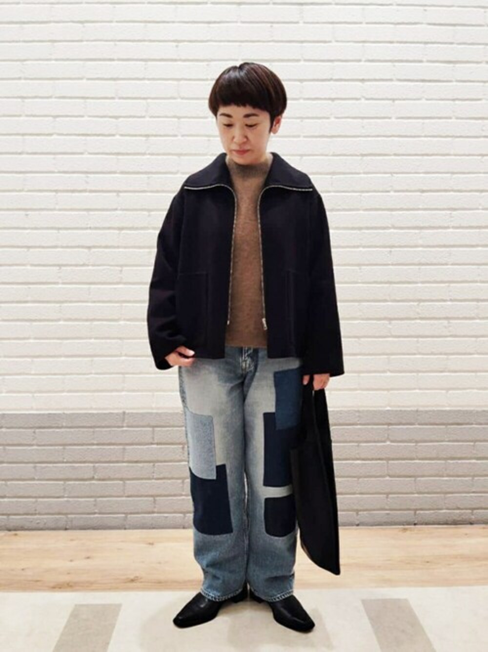 ブルー系のデニムパンツ、ブラウン系のニット/セーター、ブルー系のその他アウターを着用したレディースの冬コーディネートの1枚目の写真