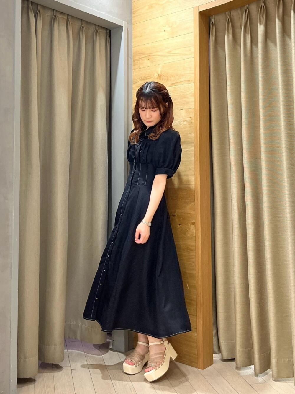 ゴールド系のサンダル、ブラック系のワンピースを着用したレディースの夏コーディネートの1枚目の写真