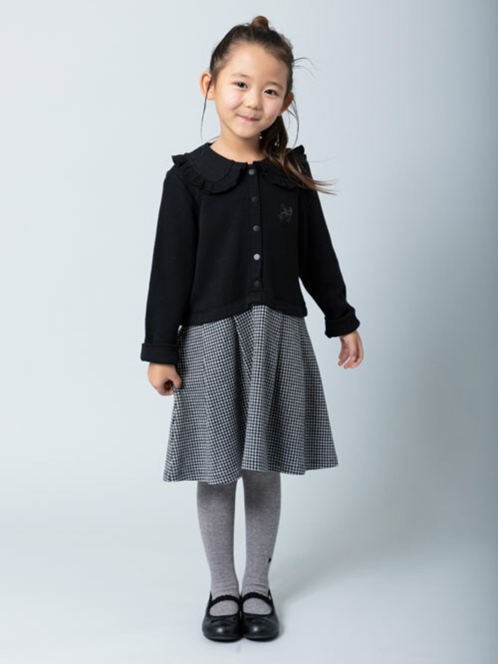 ブラック系のワンピースを着用したキッズの秋コーディネートの1枚目の写真