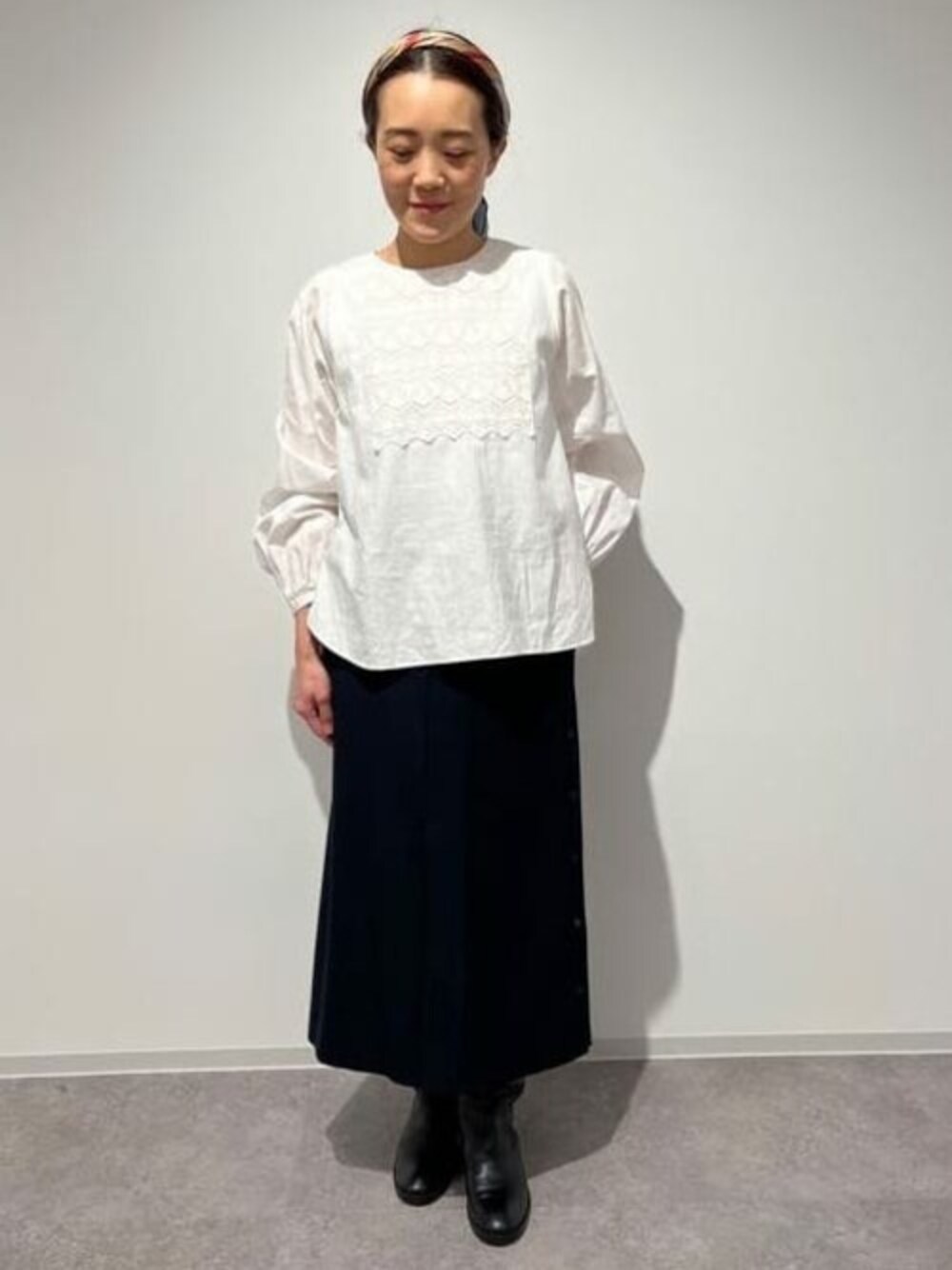 ホワイト系のシャツ/ブラウス、ブルー系のスカート、ブラック系のブーツを着用したレディースの冬コーディネートの1枚目の写真