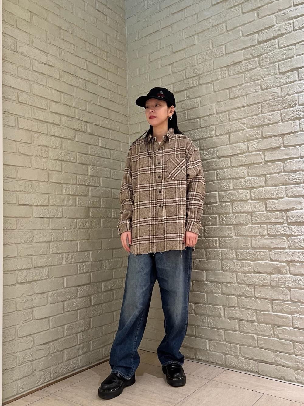 ブルー系のデニムパンツ、ベージュ系のシャツ/ブラウス、ブラック系のキャップを着用したレディースの秋コーディネートの1枚目の写真