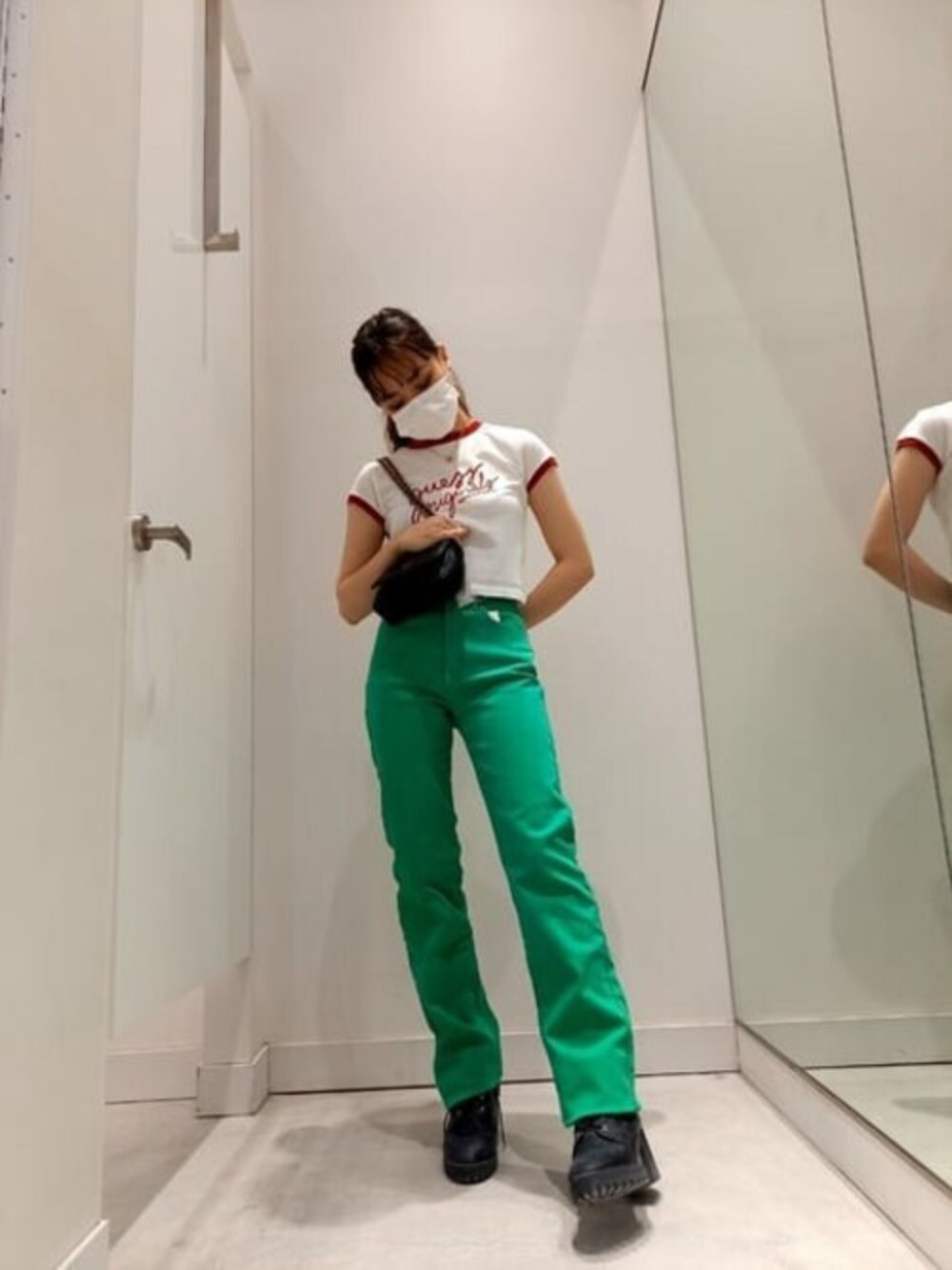 ホワイト系のTシャツ/カットソー、グリーン系のデニムパンツ、ブラック系のショルダーバッグを着用したレディースの春コーディネートの1枚目の写真