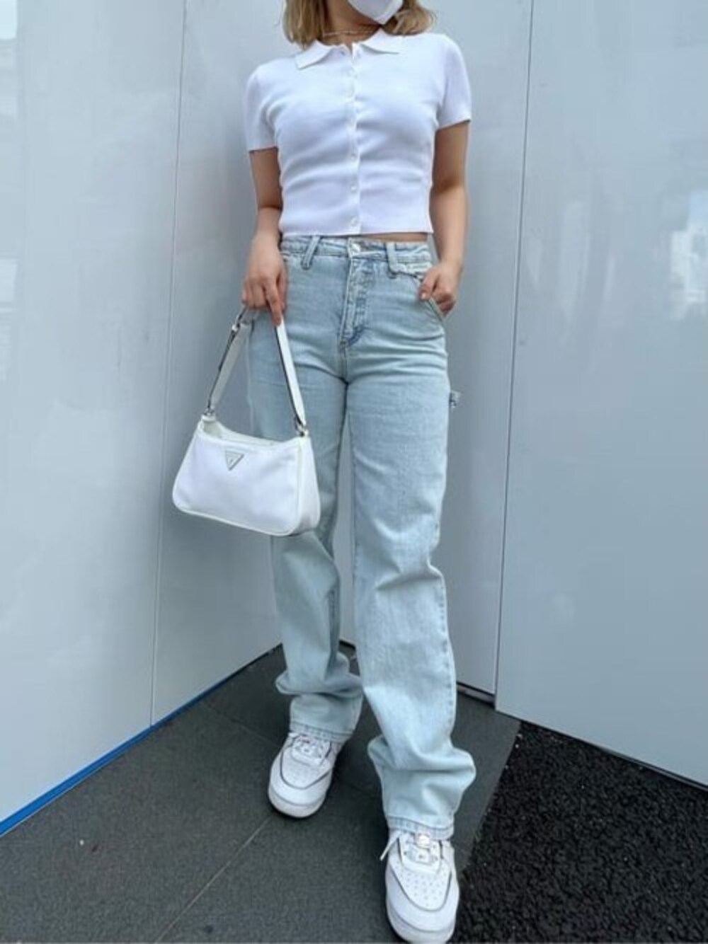 ホワイト系のポロシャツ、ブルー系のデニムパンツ、グレー系のショルダーバッグを着用したレディースの春コーディネートの1枚目の写真