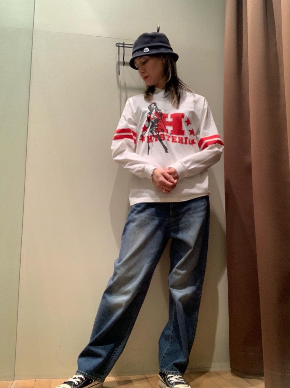 ブルー系のデニムパンツ、ホワイト系のTシャツ/カットソー、ブラック系のハットを着用したレディースの秋コーディネートの1枚目の写真